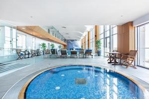 a large pool in a building with tables and chairs at Mr Neve Tsedek in Tel Aviv