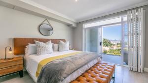 a bedroom with a large bed and a large window at Big Bay Gem in Cape Town