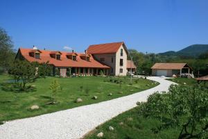 una casa con un camino de grava que conduce a una casa en Malomdűlő Farmház, en Pilisborosjenő