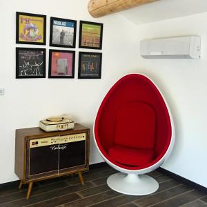 a red chair and a tv in a room at La Datcha Delicatessen in Tulette