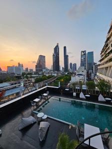 a swimming pool on top of a building with a city skyline at Sora Hotel Silom in Bangkok