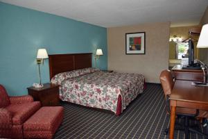 ein Hotelzimmer mit einem Bett und einem Stuhl in der Unterkunft Bonifay Inn in Bonifay