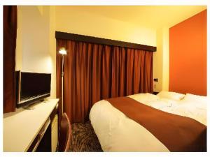 a hotel room with a bed and a flat screen tv at Nagoya Fushimi Montblanc Hotel in Nagoya