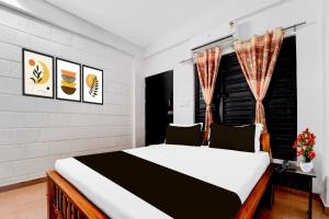 a bedroom with a large bed and a window at Super Collection O Isha Yoga Center Coimbatore Formerly Nischala Stay in Alāndurai
