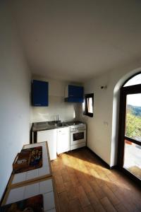 a small kitchen with blue cabinets and a window at Agriturismo Rio Lunei in Stella