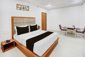 una camera da letto con un letto, un tavolo e delle sedie di Super Townhouse Oak Public Garden Hanamkonda Formerly Vishnu Grand a Warangal