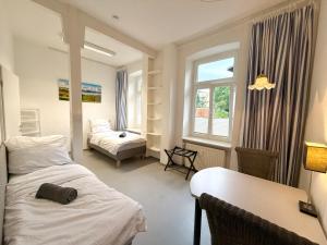 a bedroom with two beds and a desk and a window at Berta - Zentrale Wohnung - 2 Küchenzeilen - Nähe Bahnhof in Schwerin