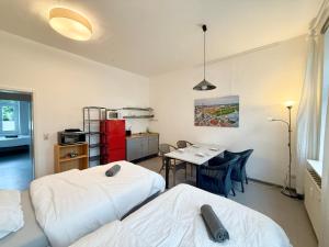 a room with two beds and a table and a kitchen at Berta - Zentrale Wohnung - 2 Küchenzeilen - Nähe Bahnhof in Schwerin