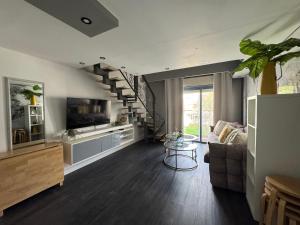 ein Wohnzimmer mit einer Treppe mit einer Couch und einem Fernseher in der Unterkunft Eilat Royal Park 97 in Eilat