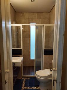 a bathroom with a toilet and a shower and a sink at Guest House Sentul by Benchmark in Citaringgul 1 +12 photos