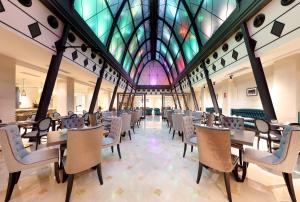 a dining room with tables and chairs and a stained glass ceiling at Eurostars Casa de la Lírica in Madrid