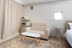 a living room with a couch and a chair at 東新宿1007 Good location within 15 minutes of Shinjuku Station in Tokyo
