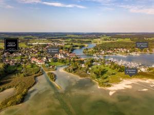 una vista aérea de un pueblo junto a un río en Designer-Oberstüberl mit Seeblick auf den Chiemsee & Alpenpanorama, en Seebruck