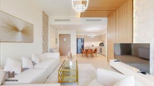 a living room with a white couch and a table at Direct Burj Khalifa & Fountain Views from Balcony ,Next to Dubai Mall Luxury 2 Bedroom - Like Home in Dubai