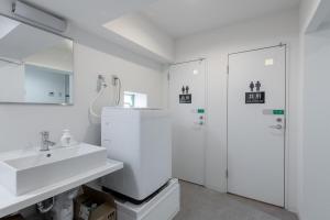a white bathroom with a sink and a shower at 東新宿1007 Good location within 15 minutes of Shinjuku Station in Tokyo +32 photos