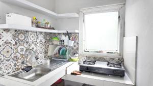 une petite cuisine avec un évier et une fenêtre dans l'établissement Damar Kusumo Exclusive Guest House, à Seturan