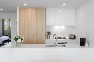 a white kitchen with a sink and a counter at Bright & Stylish 2-Bedroom Escape in Gordon in Gordon