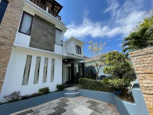 a white house with a pathway in front of it at Villa Sahadewa Pecatu in Uluwatu