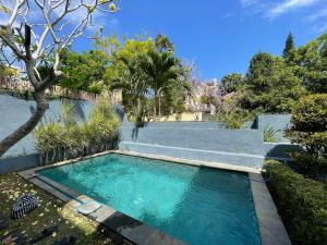 a swimming pool in the middle of a yard at Villa Sahadewa Pecatu in Uluwatu