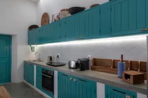una cocina con armarios de color turquesa y fregadero en Casa da Lua, en Isla de Mozambique