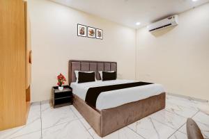 a bedroom with a large bed with white walls at Super Townhouse Oak Army Aviation Base Jhansi in Jhānsi