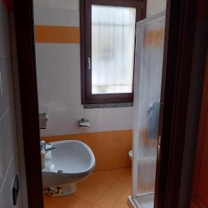 ein Badezimmer mit Waschbecken, Toilette und Fenster in der Unterkunft B&B linate in Peschiera Borromeo + 42 Fotos
