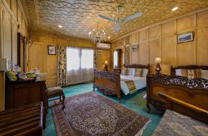 une chambre avec deux lits et un lustre dans l'établissement Dastan Heritage Houseboats, à Srinagar