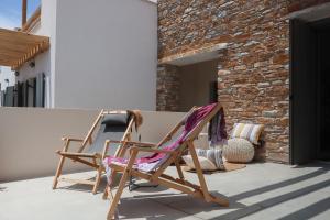 two rocking chairs sitting on a porch at Tinos Treasures Apart-Hotel in Istérnia