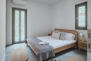 a bedroom with a bed with white sheets and pillows at Tinos Treasures Apart-Hotel in Istérnia +66 photos