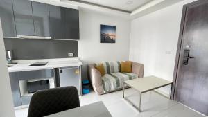 パタヤ・サウスにあるArcadia Beach-Continentalの小さなリビングルーム(椅子、テーブル付)