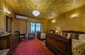 une chambre avec un lit, une commode et une fenêtre dans l'établissement Dastan Heritage Houseboats, à Srinagar 4 autres photos