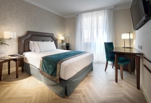 pokój hotelowy z łóżkiem, biurkiem i oknem w obiekcie Eurostars Casa de la Lírica w Madrycie
