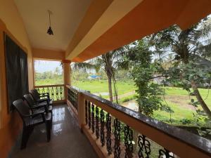 a balcony with a chair and a view of a yard at The Studio Parra in Jāmb