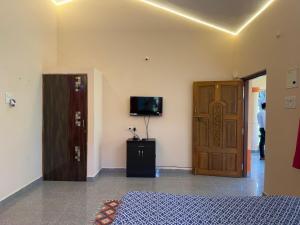 a room with a bed and a door and a television at The Studio Parra in Jāmb