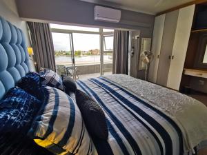 a bedroom with a bed with a blue and white comforter at Port Owen Marina by First Private Stays in Velddrif +124 photos