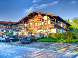 ein großes Haus mit davor geparkt in der Unterkunft Appartments Reiter am See in Inzell