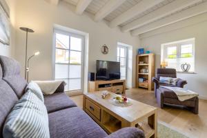 a living room with a couch and a table at Haus Wind&Wellen, Wohnung Hafen in Wittdün