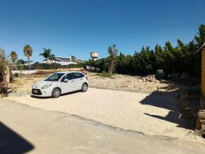 a white car parked on the side of a road at M'arriposu in Realmonte