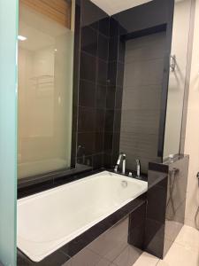 a bath tub with a large mirror in a bathroom at Family Suites KL Sentral in Kuala Lumpur +12 photos