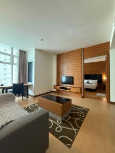 a living room with a bed and a television at Family Suites KL Sentral in Kuala Lumpur