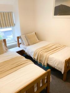 ein Zimmer mit zwei Betten und einem Fenster in der Unterkunft Dolbach Cottage Snowdonia in Blaenau-Ffestiniog