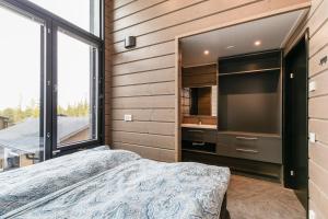 a bedroom with a bed and a large screen tv at Kinos A Visit Levi in Levi