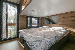 a bedroom with a bed in a room with windows at Kinos A Visit Levi in Levi