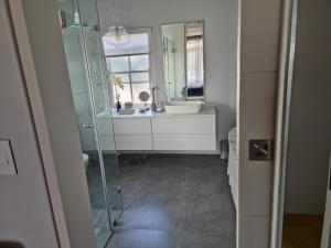a bathroom with a sink and a mirror at Winelands Golf Lodges 34 at De Zalze in Onder-Papegaaiberg