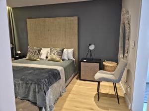 a bedroom with a bed and a chair at Winelands Golf Lodges 34 at De Zalze in Onder-Papegaaiberg
