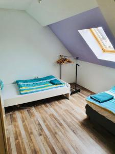 a attic room with a bed and a skylight at BB Crew House in Stipshausen