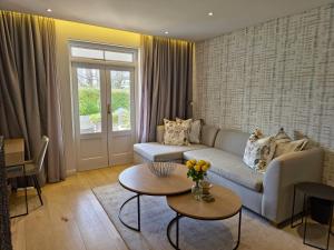 a living room with a couch and a table at Winelands Golf Lodges 34 at De Zalze in Onder-Papegaaiberg +16 photos