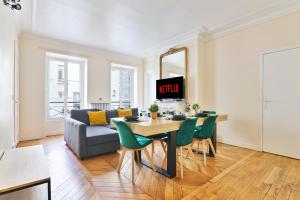 a living room with a table and a couch at Arc de Triomphe Superbe Appartement Paris Free Netflix in Paris