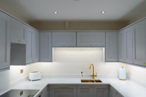 a kitchen with gray cabinets and a sink at Luxury Flat in Shaftesbury by JOT STAYS in Shaftesbury