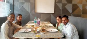 un grupo de personas sentadas en una mesa en un restaurante en Hotel Simla, en Siliguri 15 fotos más